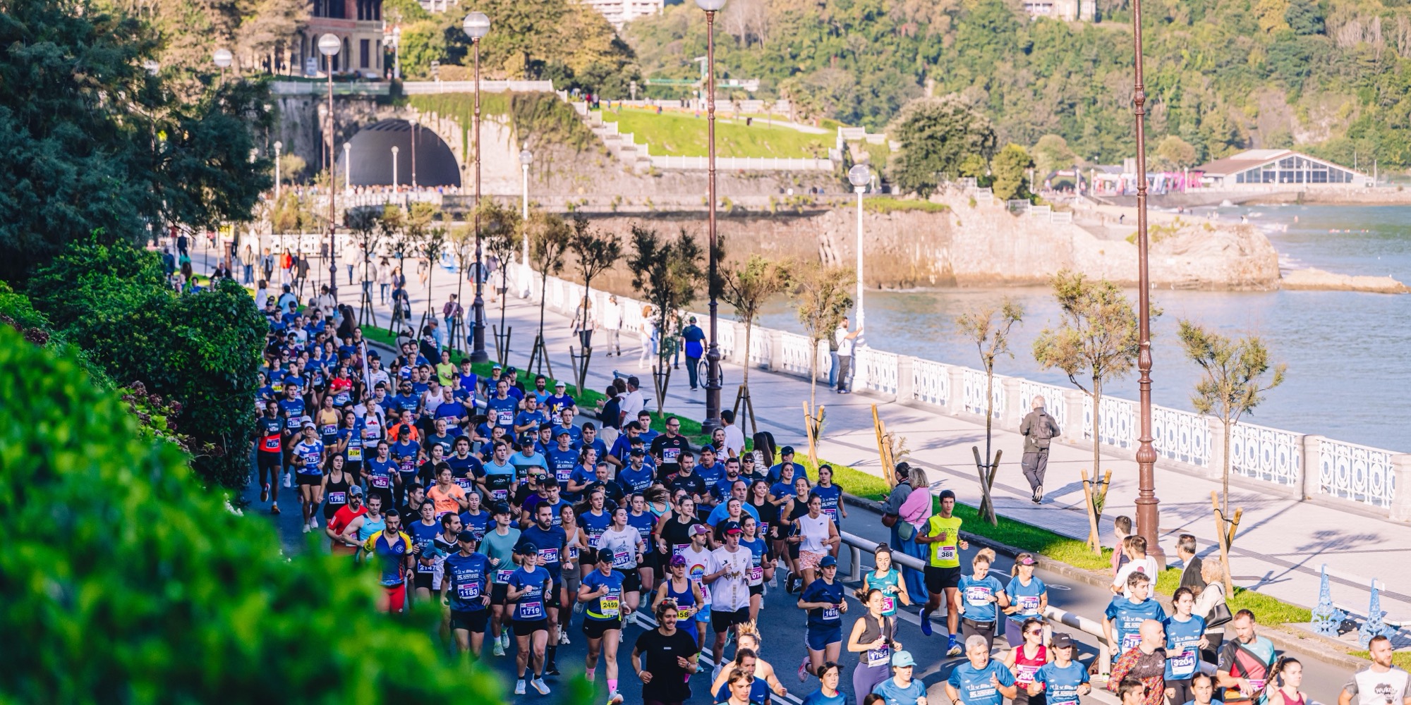 Pelotón de corredores junto al mar en San Sebastián